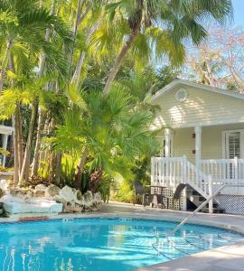 a house with a swimming pool in front of a house at Westwinds Inn in Key West