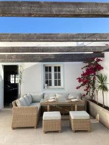 a patio with a couch and a table and chairs at Casa Monte Tamissa in Vila Real de Santo António