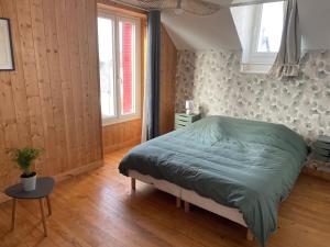 ein Schlafzimmer mit einem grünen Bett und einem Tisch in der Unterkunft Gîte Le Riviéra 