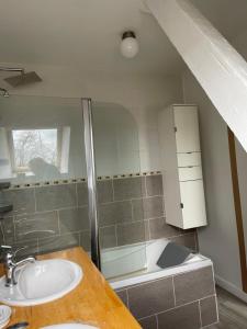 een badkamer met een wastafel en een bad bij Gîte Le Riviéra 