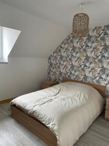 een bed in een slaapkamer met een muur bij Gîte Le Riviéra 