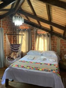a bedroom with a bed and a hammock at Pousada Tarumã challes 01 in Bonito