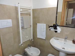 un bagno con lavandino, water e specchio di Monolocale Via Cerquiglia, 136 a Spoleto Altre 24 foto