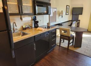 una pequeña cocina con fregadero y mesa en Candlewood Suites Greenville NC, an IHG Hotel en Greenville