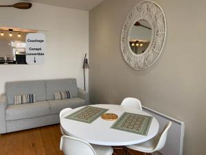 ヴィムルーにあるStudio (Coup de Coeur) Wimereuxのリビングルーム(白いテーブル、椅子、鏡付)