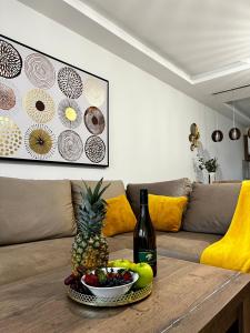 a table with a bowl of fruit and a bottle of wine at Sunshine Homes Zamárdi in Zamárdi