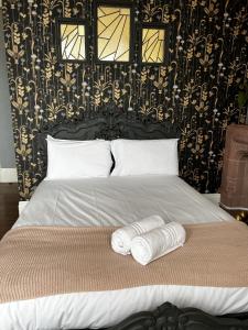 Una cama con dos toallas encima. en The Commodore Rooms & Relaxation, en Paignton