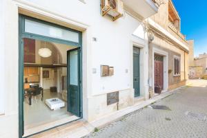 um edifício com grandes portas de vidro numa rua em L'Appartamentino Holiday Home em Lecce