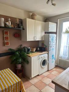 a kitchen with a refrigerator and a washing machine at PARIS 14e centre avec cuisine in Paris