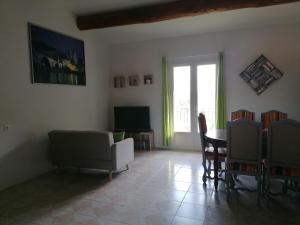 ein Wohnzimmer mit einem Sofa und einem Tisch in der Unterkunft Le Tavan in Crillon-le-Brave