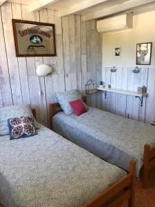 2 Betten in einem Zimmer mit Holzwänden in der Unterkunft Le Tavan in Crillon-le-Brave