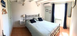 ein Schlafzimmer mit einem großen Bett mit blauen Kissen in der Unterkunft Le Tavan in Crillon-le-Brave