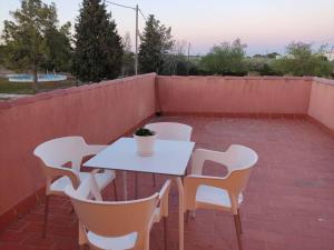 una mesa blanca y sillas en un patio de ladrillo en Casa Laurel, en Camarles