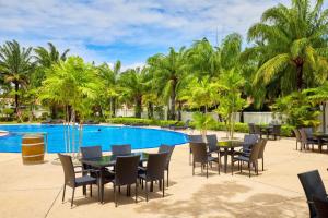 um pátio com mesas e cadeiras ao lado de uma piscina em View Talay Villas, luxury private pool villa, 500m from Jomtien beach - 45 em Praia de Jomtien