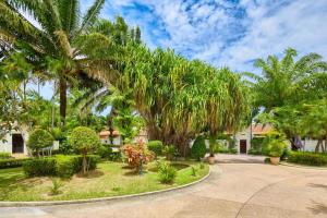 eine Villa mit Palmen und einer Auffahrt in der Unterkunft View Talay Villas, luxury private pool villa, 500m from Jomtien beach - 45 in Jomtien Beach