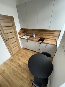 a small kitchen with a black chair and a sink at Airport Apartment 32 self check-In Free Parking in Vilnius
