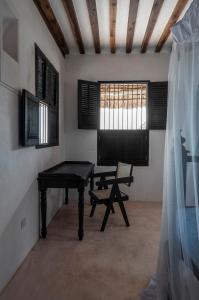 um quarto com uma mesa, um banco e uma janela em Amma's House em Lamu