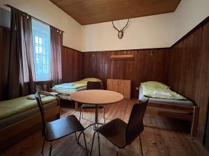 WaldにあるFerienhaus ZUR ALTEN FORSTKANZLEIのベッド2台、テーブル、椅子が備わる客室です。