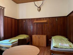 Zimmer mit 2 Betten und einem Tisch in der Unterkunft Ferienhaus ZUR ALTEN FORSTKANZLEI in Wald