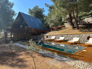 ein Haus mit einem Pool und einer Terrasse in der Unterkunft Panurlawoodenhouse özel havuz& sauna mavi in Urla