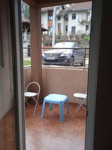 a blue table and chairs on a balcony with a car at Benvenuto in Vrnjačka Banja
