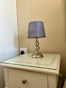 a lamp on top of a dresser with a mirror at Aerodrome Lodge and Conference Centre in Benoni