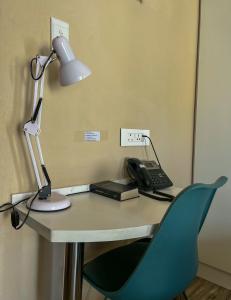 a desk with a lamp and a phone on it at Aerodrome Lodge and Conference Centre in Benoni