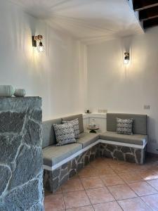un divano in una camera con parete in pietra di Casa del Mate ad Alghero