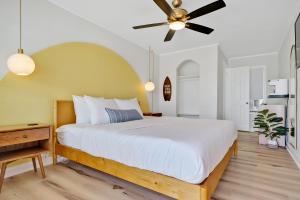 a bedroom with a large bed with a ceiling fan at The Starlite Inn in Carolina Beach