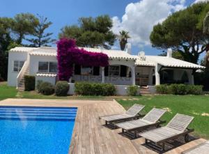 una casa con piscina e due sedie a sdraio di VILLA CAP DENT FONT a Binissafuller