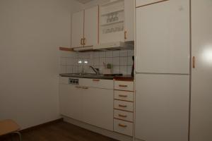 een keuken met witte kasten en een koelkast bij HusHotellHunge AB in Bräcke