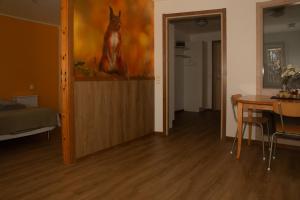 a living room with a table and a painting of a deer at HusHotellHunge AB in Bräcke