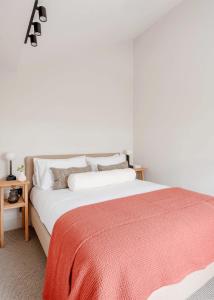 ein Schlafzimmer mit einem großen weißen Bett mit einer roten Decke in der Unterkunft Notting Hill Gate Residence VI in London