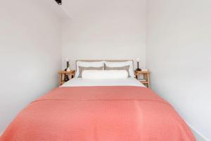 ein Schlafzimmer mit einem Bett mit einer roten Decke in der Unterkunft Notting Hill Gate Residence VI in London