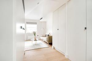 a hallway with white walls and a living room at Notting Hill Gate Residence VI in London