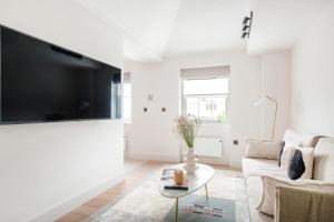 ein weißes Wohnzimmer mit einem großen Flachbild-TV in der Unterkunft Notting Hill Gate Residence VI in London