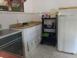 uma cozinha com um lavatório e um frigorífico em Solo Buziano- Casa de Temporada em Búzios