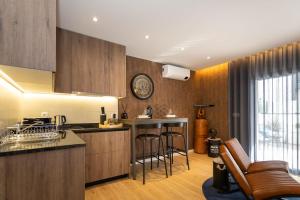 a kitchen with wooden cabinets and bar stools at Marinha Grande Apartamentos N4 FACTORY in Marinha Grande