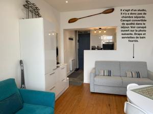 ein Wohnzimmer mit einem Sofa und einem Stuhl in der Unterkunft Studio (Coup de Coeur) Wimereux in Wimereux