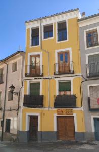 un edificio amarillo con ventanas y balcones en La Casita del Río - Riverside Home, en Cuenca
