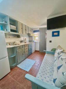 a kitchen with blue cabinets and a white refrigerator at A Berlenga 3 in Nazaré