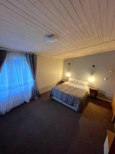 a bedroom with a bed and a large window at Amplia Casa 3 Dormitorios 2B in Puerto Montt