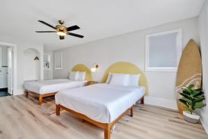 The Starlite Inn في كارولينا بيتش: غرفة نوم بسريرين ومروحة سقف