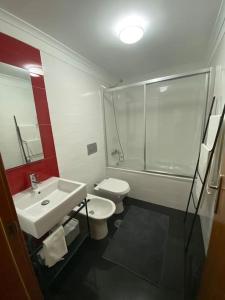 La salle de bains est pourvue d'un lavabo, de toilettes et d'une douche. dans l'établissement Prime Location - Historic District with Private Parking, à Lisbonne