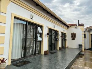a building with large glass doors on a courtyard at Aerodrome Lodge and Conference Centre in Benoni