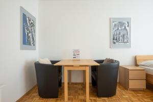 stół i krzesła w pokoju z łóżkiem w obiekcie Central living - Stephansdom Apartments w Wiedniu +37 zdjęć