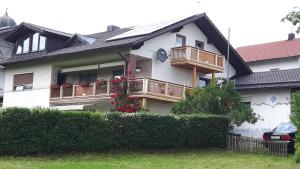 a house with a balcony and a fence at Ferienwohnung Langdorf in Langdorf im Landkreis Regen