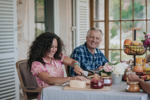 a man and woman sitting at a table cutting food at Domaine des Chailloux 