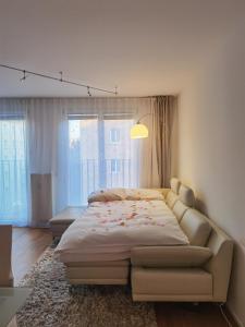 a bedroom with a large bed and a couch at Modernes Studio-Apartment nahe Zentrum mit Garagenplatz in Vienna