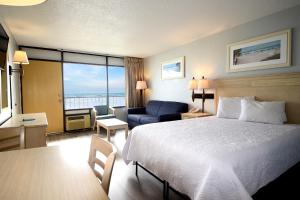 a hotel room with a bed and a desk and a chair at Holiday Sands North "On the Boardwalk" in Myrtle Beach
